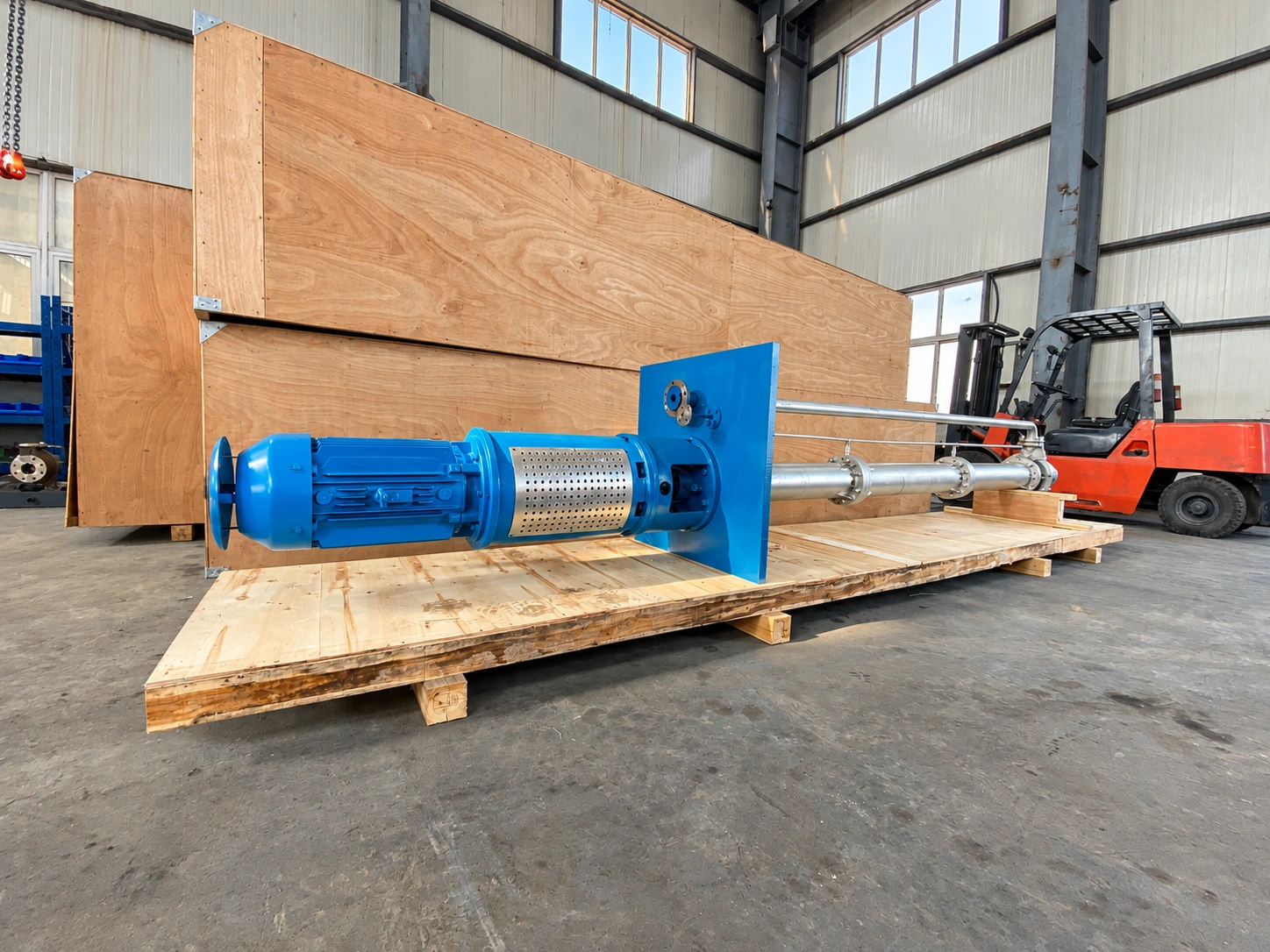 Bomba azul de columna larga colocada horizontalmente sobre un palé de madera.